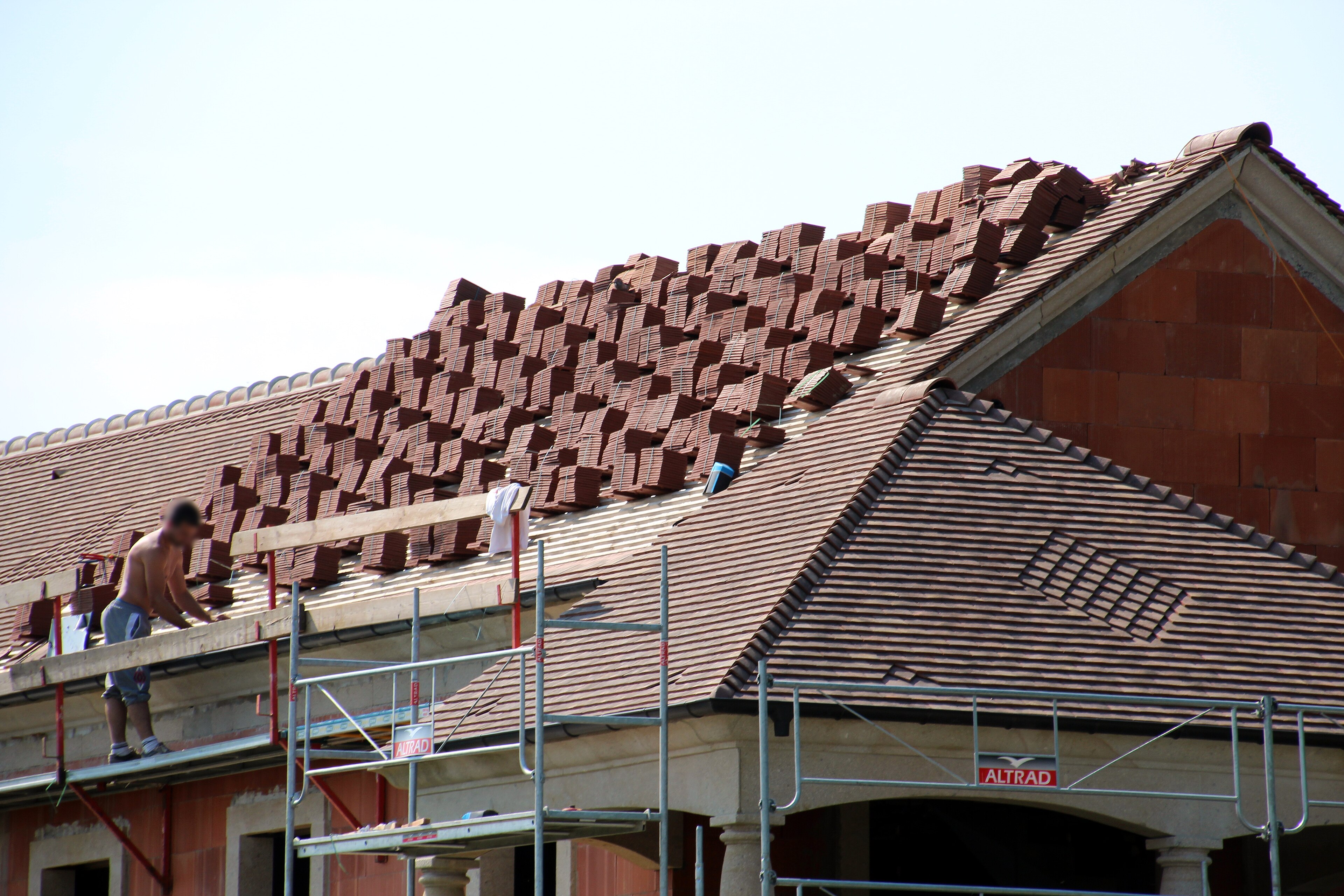Chantier de toiture avec pose de tuiles sur une maison en France